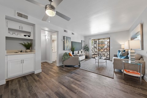 A living room with a grey sofa and a glass coffee table.