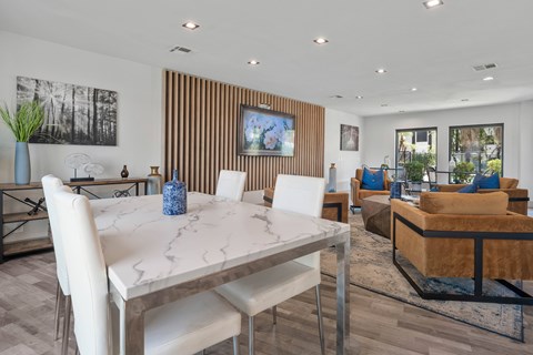 A modern dining room with a white marble table and chairs.