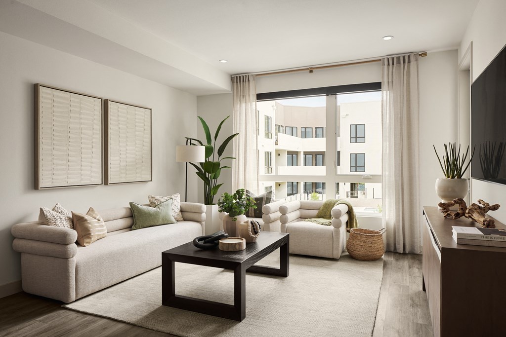 a living room with white walls and a large window