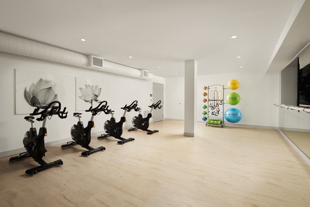 a room with exercise machines and paintings on the wall