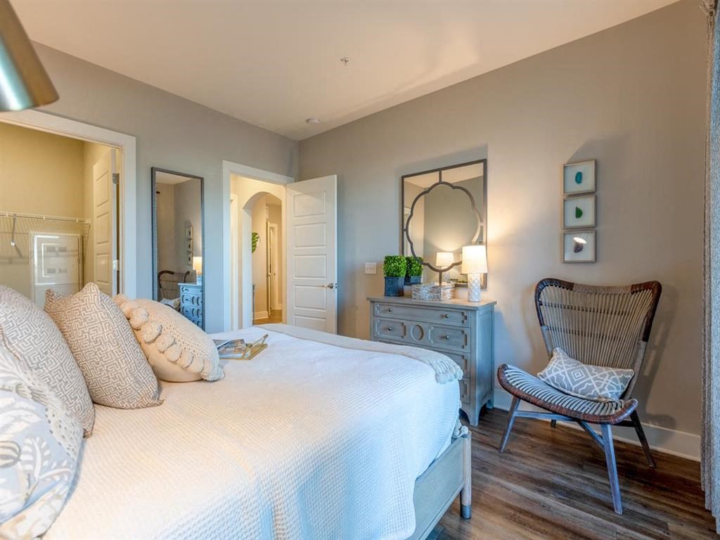 a bedroom with a bed and a dresser and a mirror