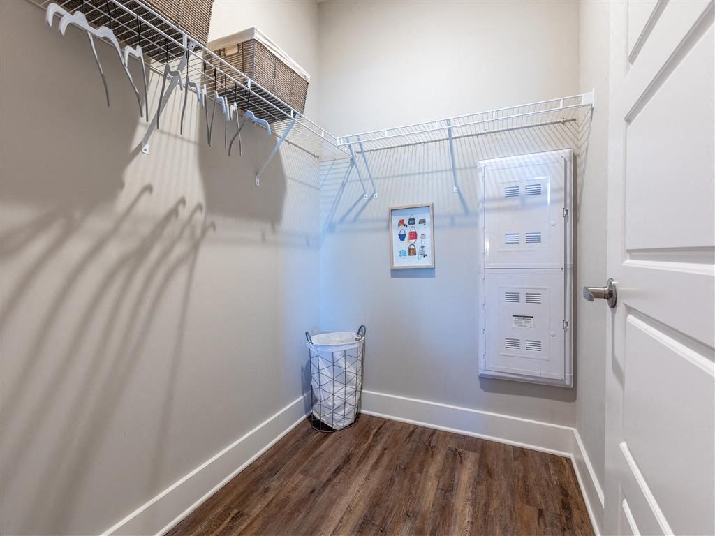 a laundry room with a washer and dryer on the wall and a closet