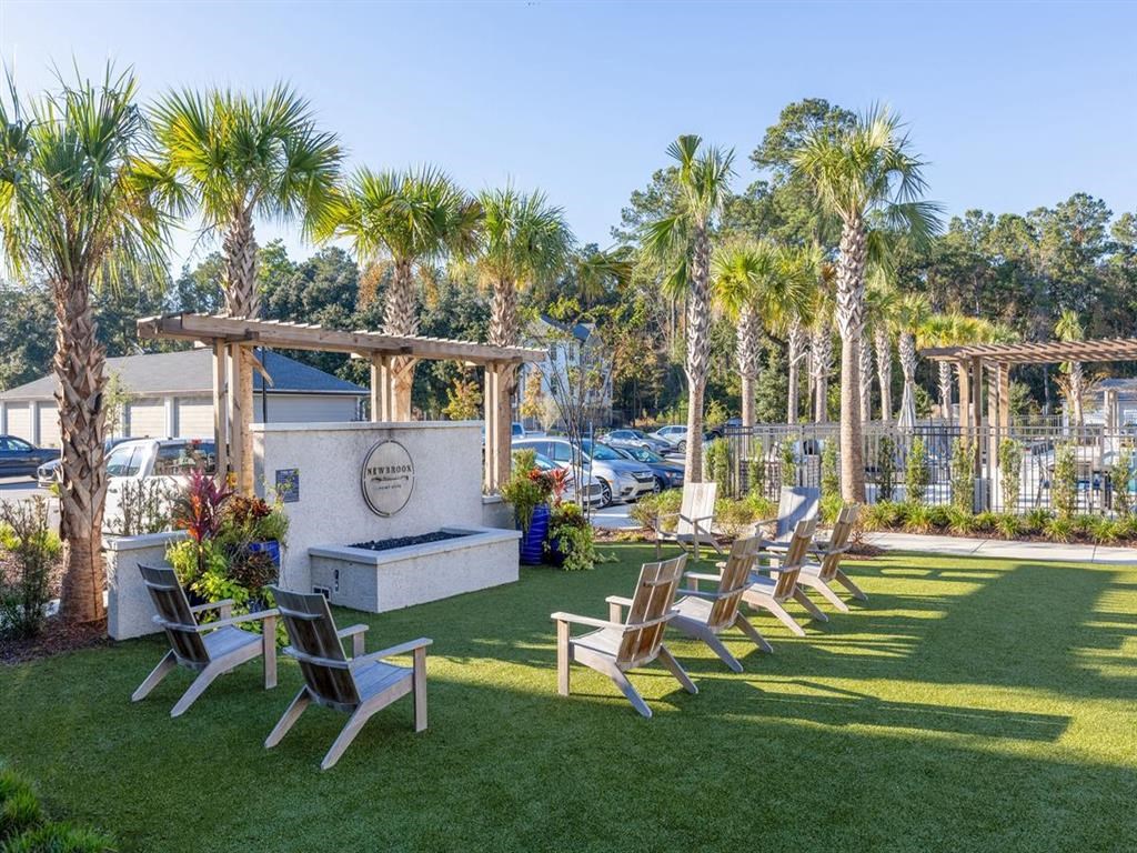 a row of lawn chairs in front of a pool and palm trees