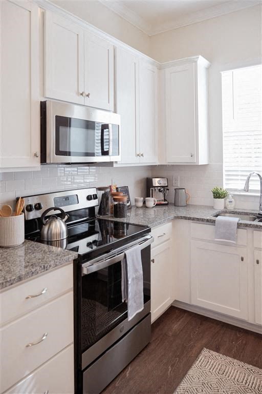 a kitchen with a stove a microwave and a sink