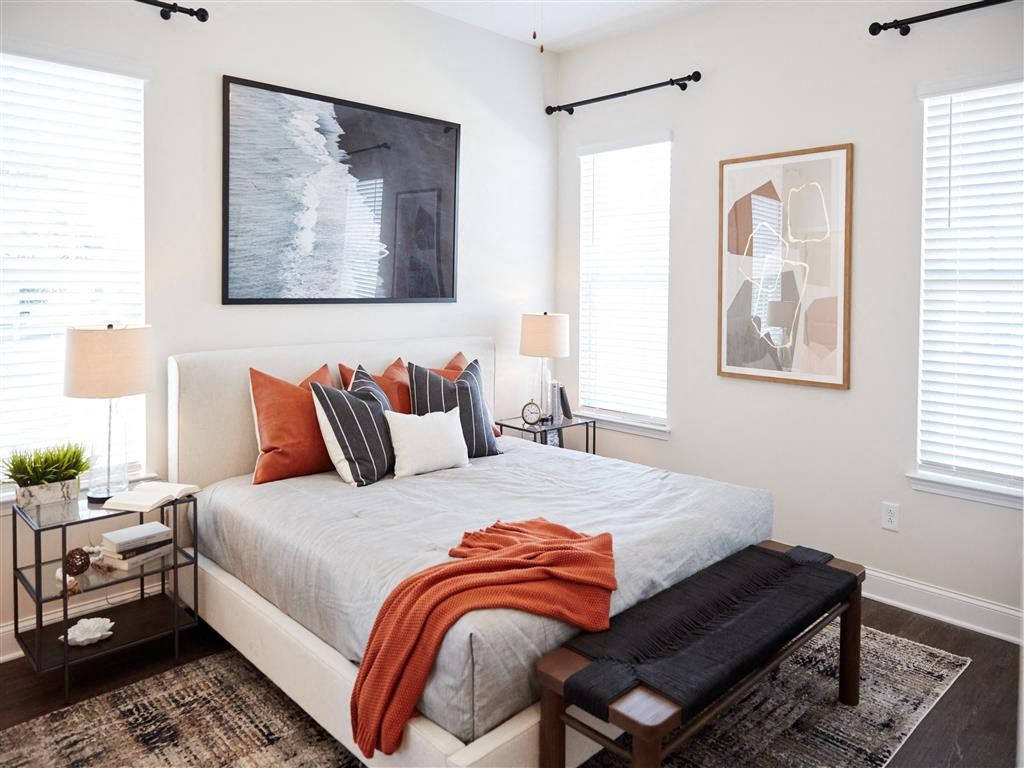 a bedroom with a large bed and three windows