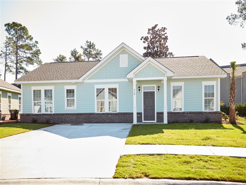 a blue house with a sidewalk in front of it