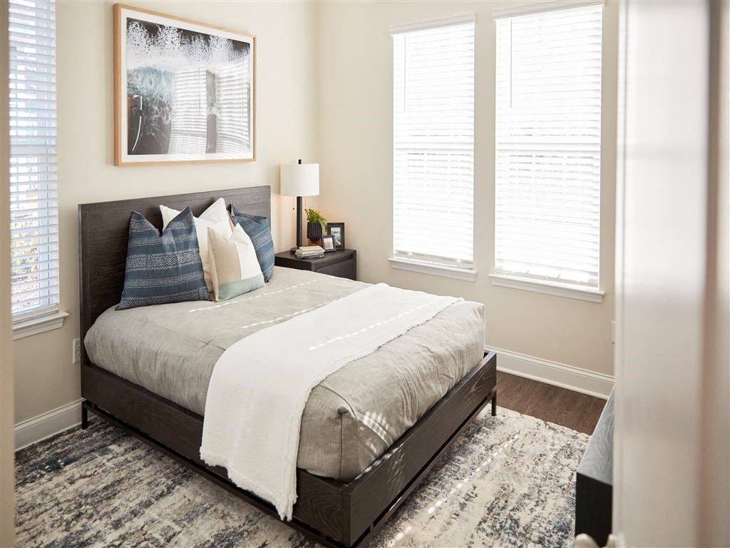 a bedroom with a bed and three windows