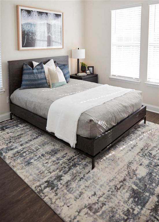 a bedroom with a bed and two windows