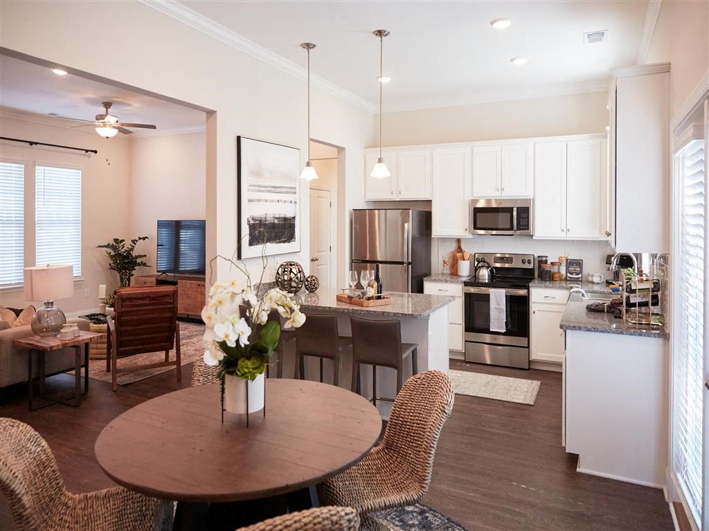 a kitchen and living room with a table and chairs