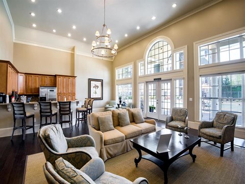 A well-lit living room with a large table and chairs.