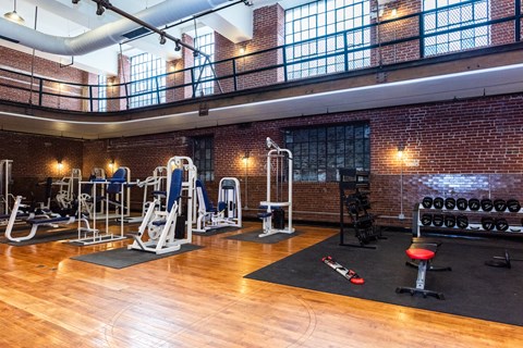 A gym with a variety of equipment including weights and machines.