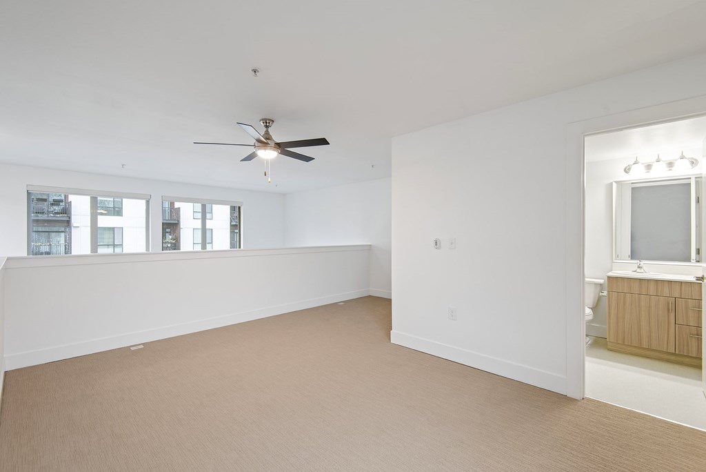 A room with a ceiling fan and a window.