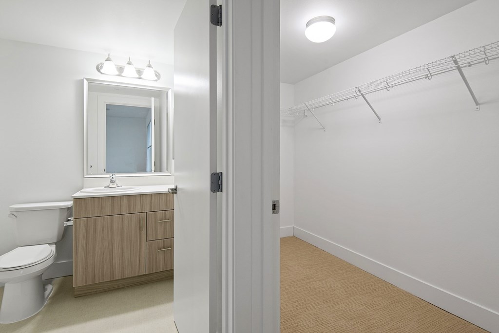 A white bathroom with a toilet, sink, and a cabinet.