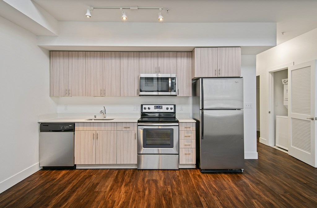 A kitchen with wooden floors and stainless steel appliances.