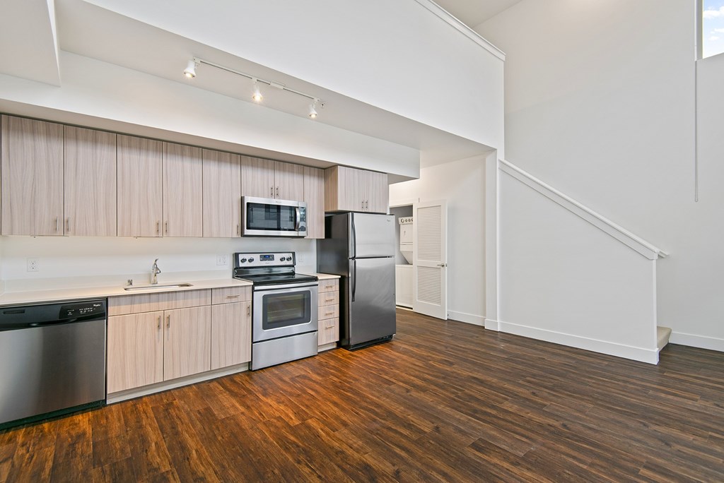 A kitchen with wooden floors and stainless steel appliances.