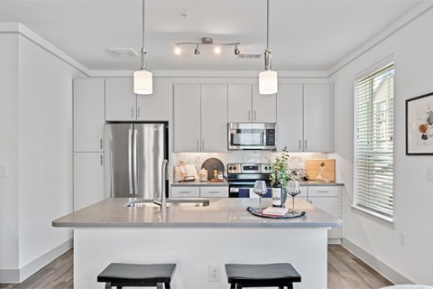 A modern kitchen with a stainless steel refrigerator and a center island.