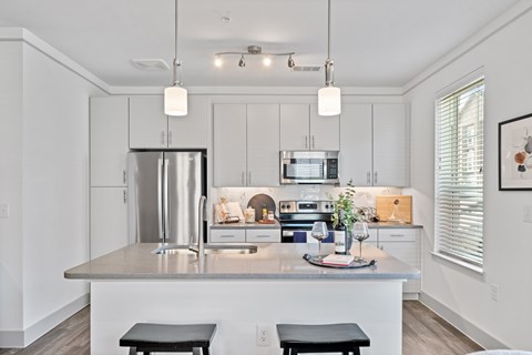 A modern kitchen with a stainless steel refrigerator and a center island.