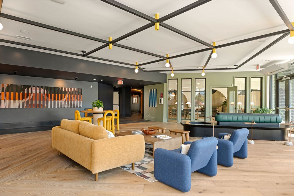 A living room with a yellow couch and blue chairs.