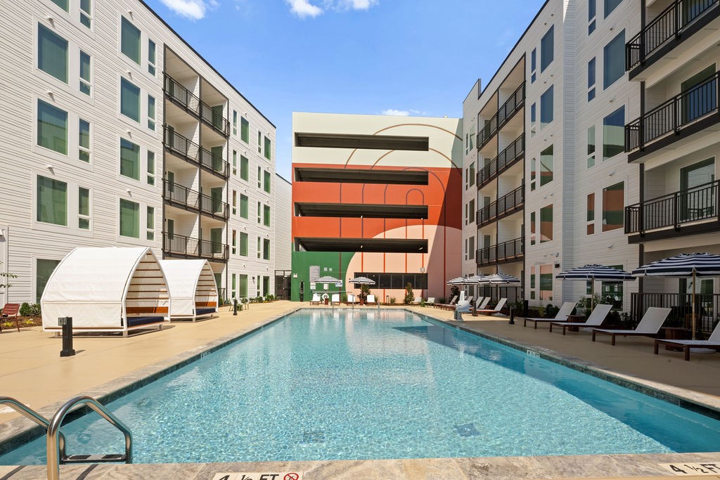 A swimming pool in front of apartment buildings.