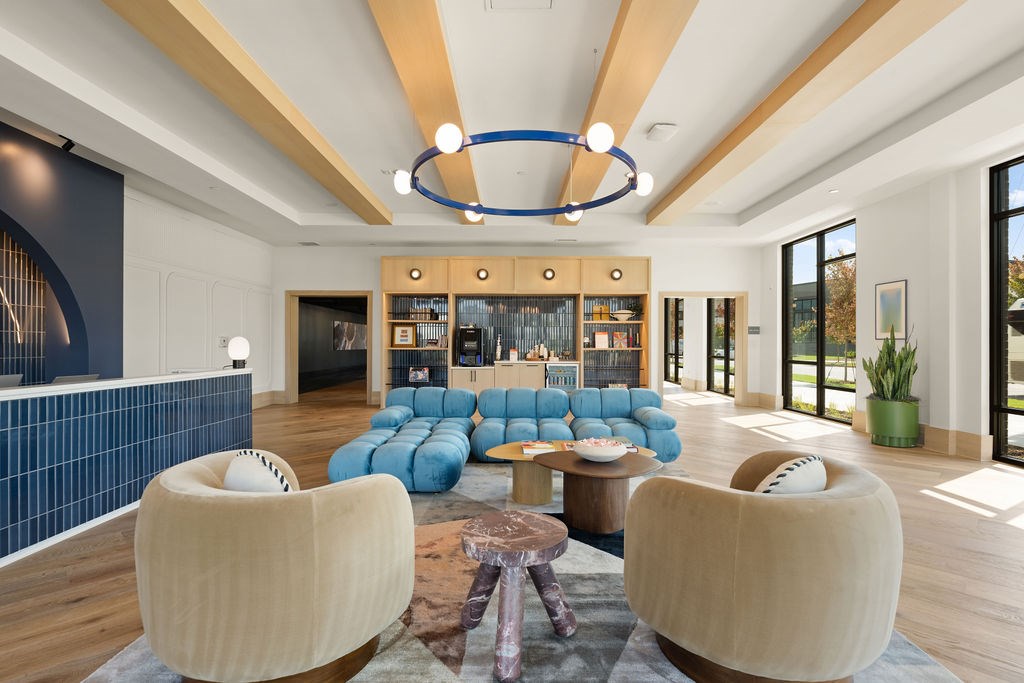 A modern living room with a blue sofa and wooden furniture.