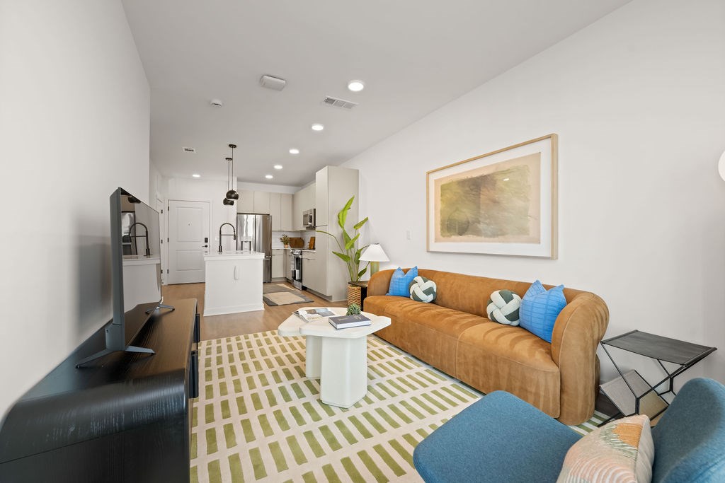 A living room with a brown couch and a white coffee table.