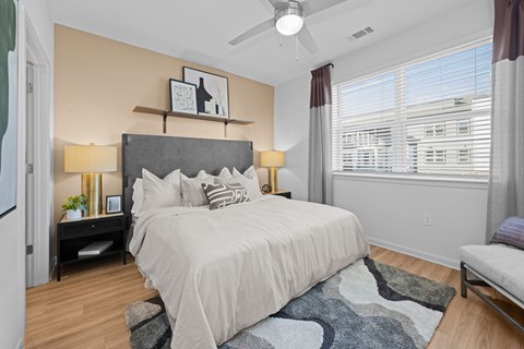 A bedroom with a large bed and a ceiling fan.