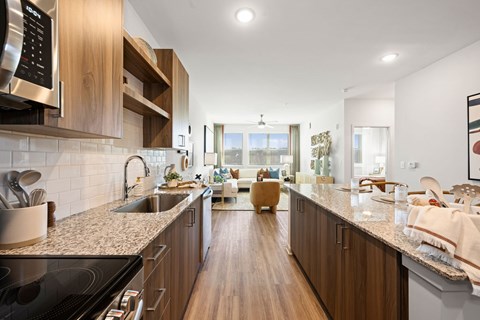 A modern kitchen with wooden cabinets and a marble countertop.