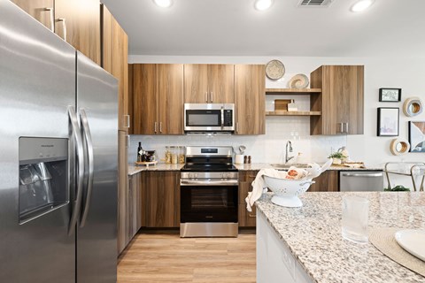 A modern kitchen with a stainless steel refrigerator and wooden cabinets.