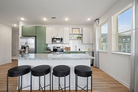 A kitchen with a bar stool in front of it.