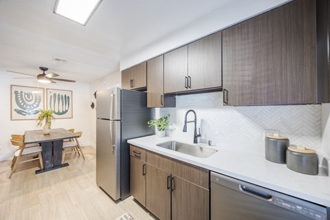 a kitchen with wooden cabinets and a stainless steel refrigerator