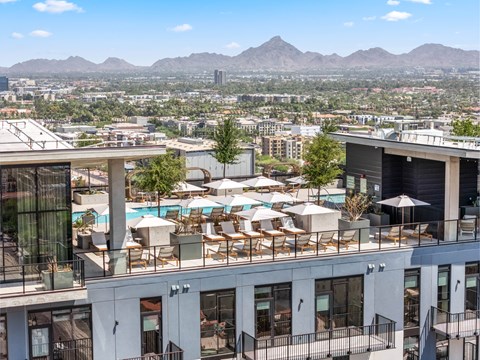 A view of a pool area with chairs and umbrellas from a high-rise building.