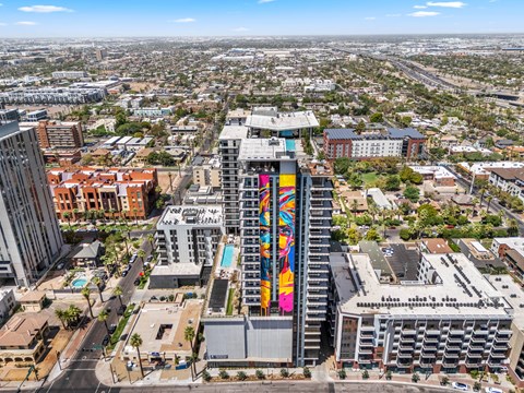 Exterior building with a colorful mural on the side stands out in a cityscape.