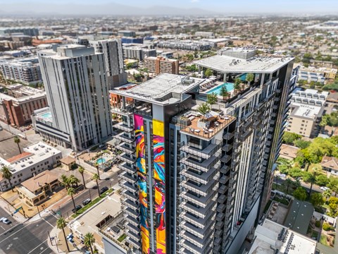 Exterior building with a colorful mural on its side stands out against the cityscape.
