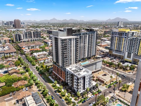 Exterior building with a pool on the roof is surrounded by other buildings