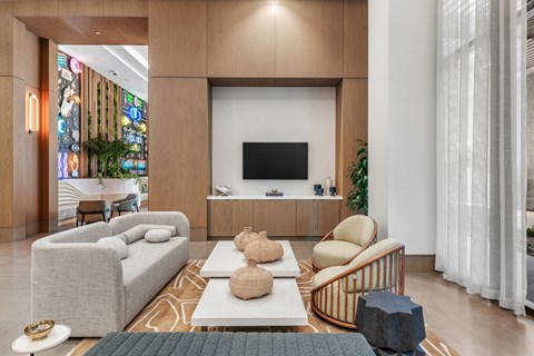 A modern living room with a grey sofa, a white coffee table, and a TV on a wooden cabinet.