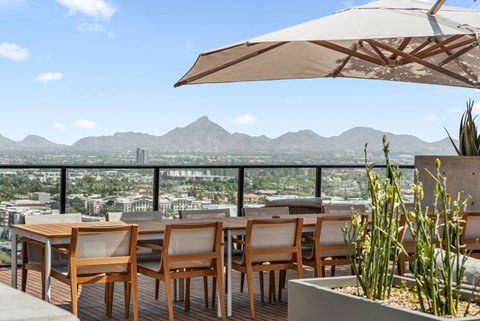 Exterior patio with a table and chairs overlooking a cityscape.