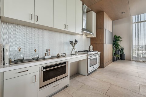 A modern kitchen with stainless steel appliances and white cabinets.