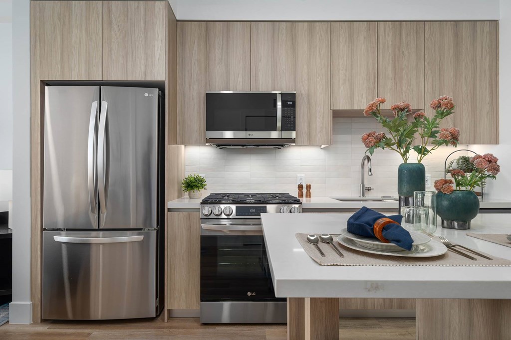 A modern kitchen with a stainless steel refrigerator and a white countertop.