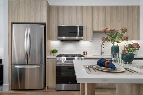 A modern kitchen with a stainless steel refrigerator and a white countertop.