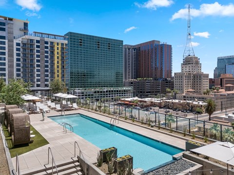 A pool area with a view of the city skyline.
