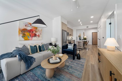 A modern living room with a grey sofa and a wooden coffee table.