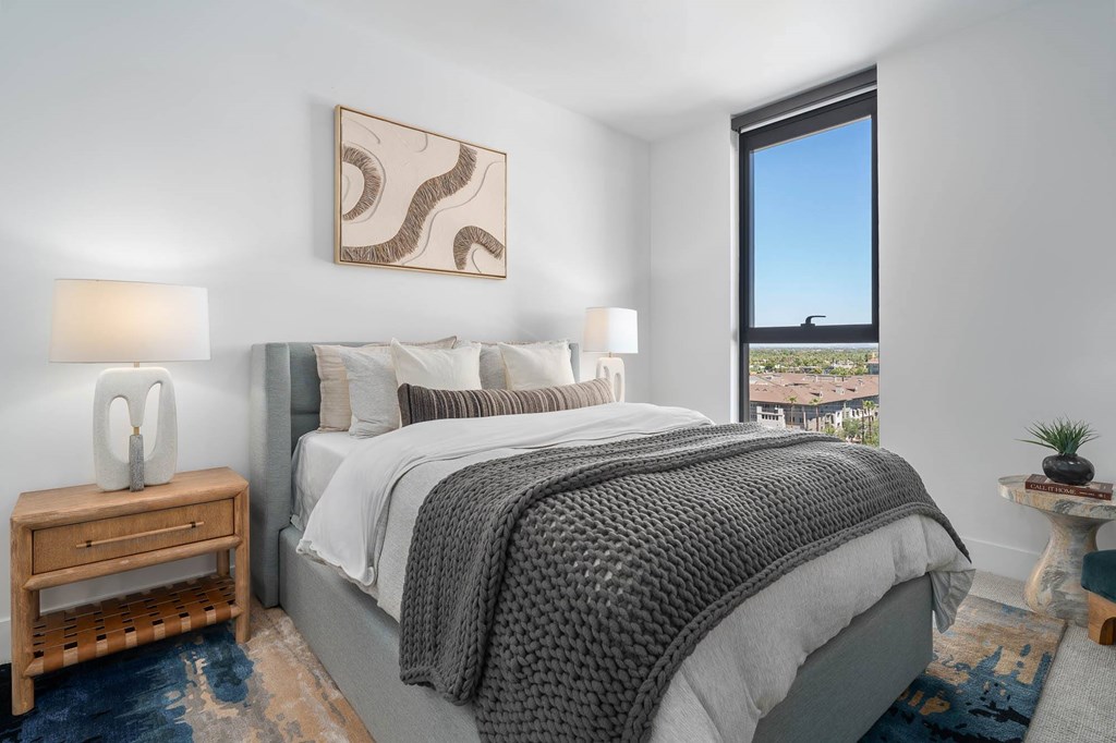 A bedroom with a large bed and a view of the city.