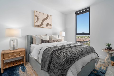 A bedroom with a large bed and a view of the city.