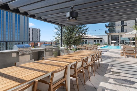 Outdoor long table with chairs, BBQ grills by the pool