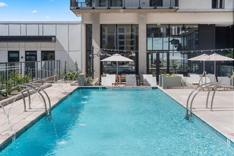 A swimming pool in front of exterior building.