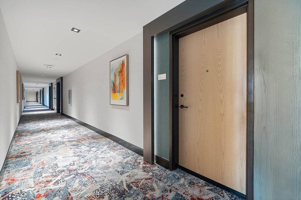 Interior building facing front unit door, carpet, wood frame door