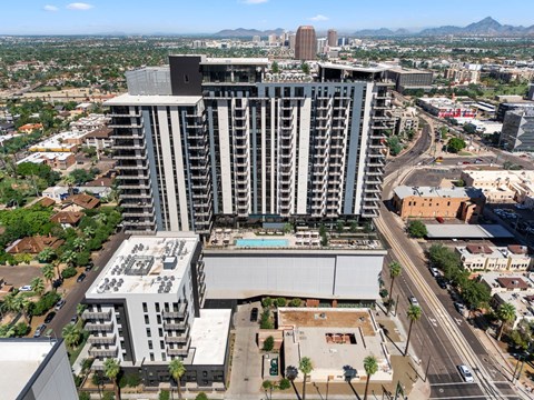 Exterior building with a pool on the roof is surrounded by other buildings