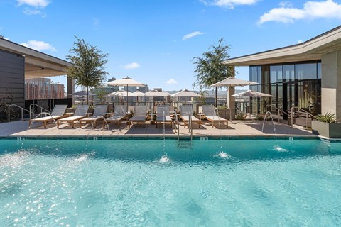 Roof-top pool with lounge seating, umbrellas.