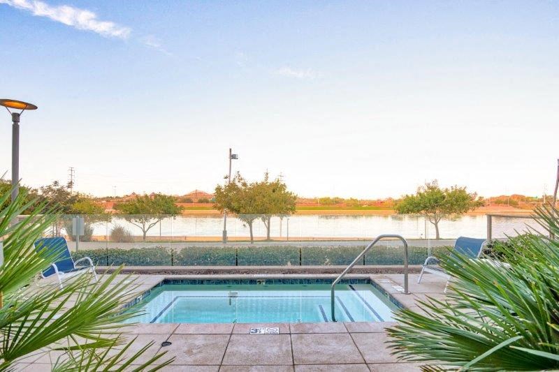 a swimming pool with two blue chairs next to it