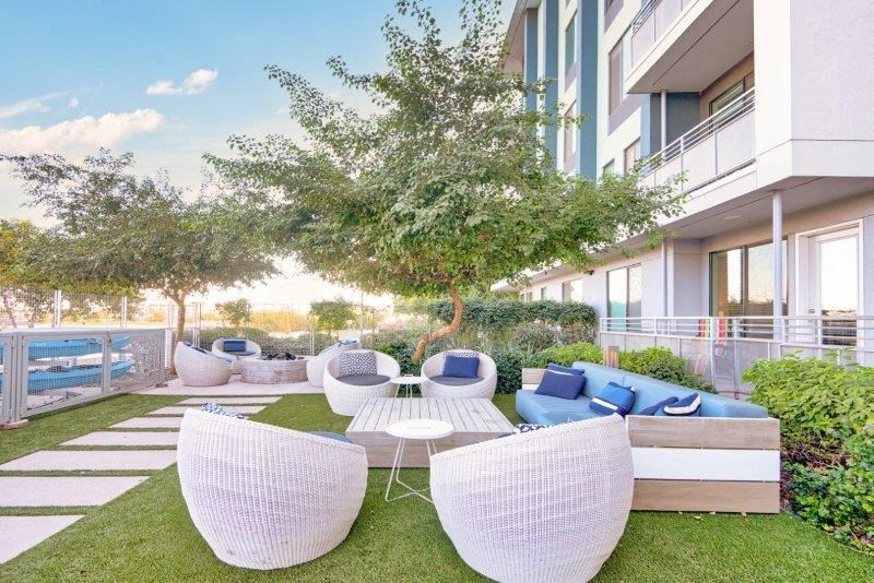 an apartment patio with white chairs and blue and white furniture
